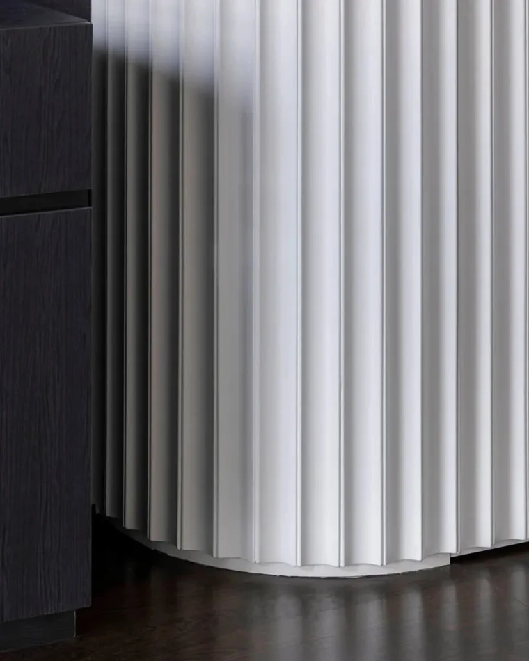 Curved timber slat panelling sharing the cabinet junction detail